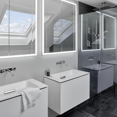 Badeværelse under taget med to håndvaske og spejle