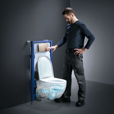 En mand betjener TurboFlush-skylleteknikken på et Geberit Acanto-toilet
