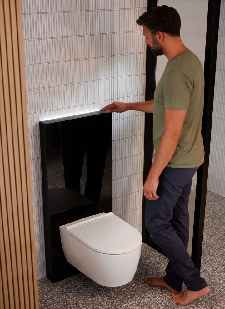 Mand ved siden af Geberit Monolith Plus med ComfortLight Mand ved siden af Geberit Monolith Plus med ComfortLight