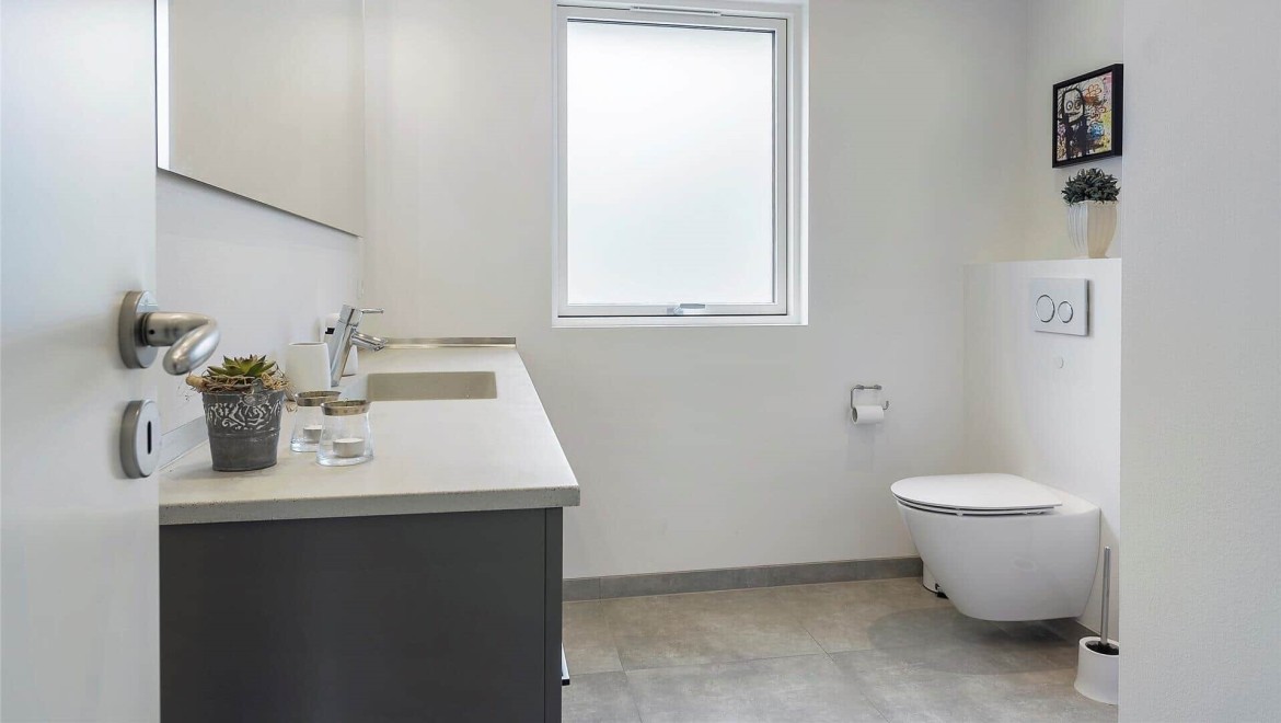 Badeværelse med toilet og badeværelsesmøbel Badeværelse med toilet og badeværelsesmøbel
