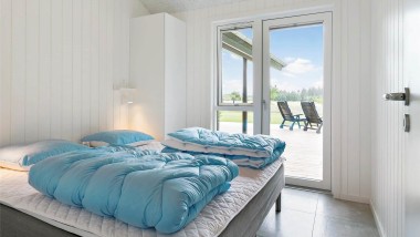 Soveværelse med stor seng i sommerhus