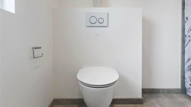 Væghængt Ifö toilet med Geberit betjeningsplade på sommerhus badeværelse