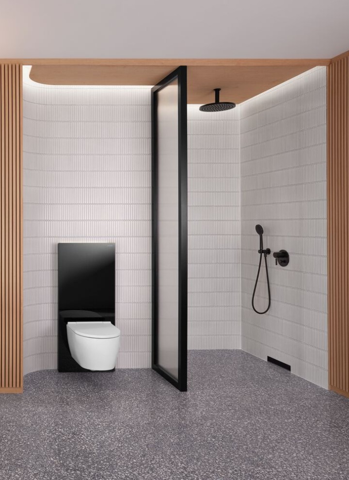 Et badeværelse med en trævæg og et bruse- og toiletområde i sort og hvid