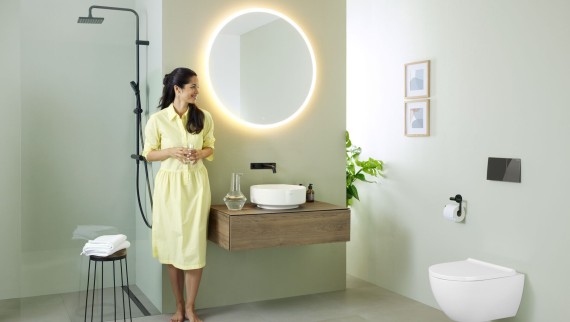 Kvinde på badeværelse med Geberit Option-spejl og Geberit VariForm-håndvask