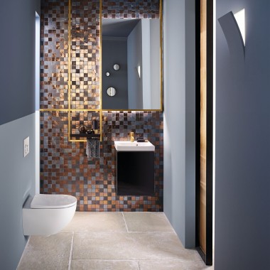 Udsigt til et moderne gæstebadeværelse med et Acanto toilet og en Acanto håndvask foran et mosaik bagpanel