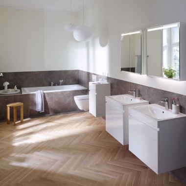 Et trægulv i et sildebensmønster gør sig også godt i badeværelset. Tidløse badeværelsesmøbler passer perfekt dertil.