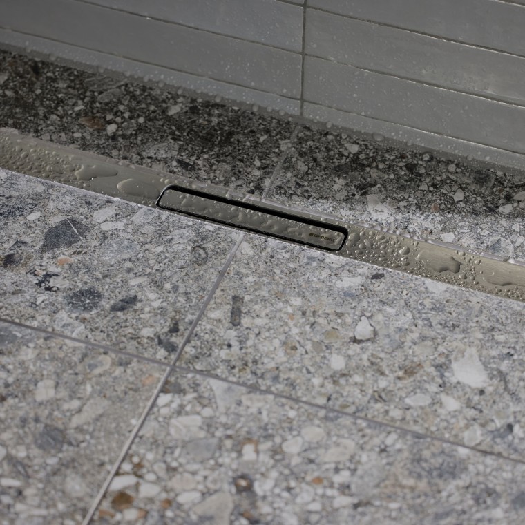 Vandet løber ud via en elegant profil i rustfrit stål. Vandet løber ud via en elegant profil i rustfrit stål.