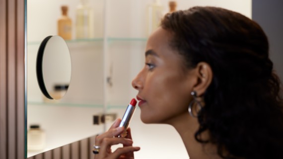 Kvinde med læbestift foran spejl (© Geberit)