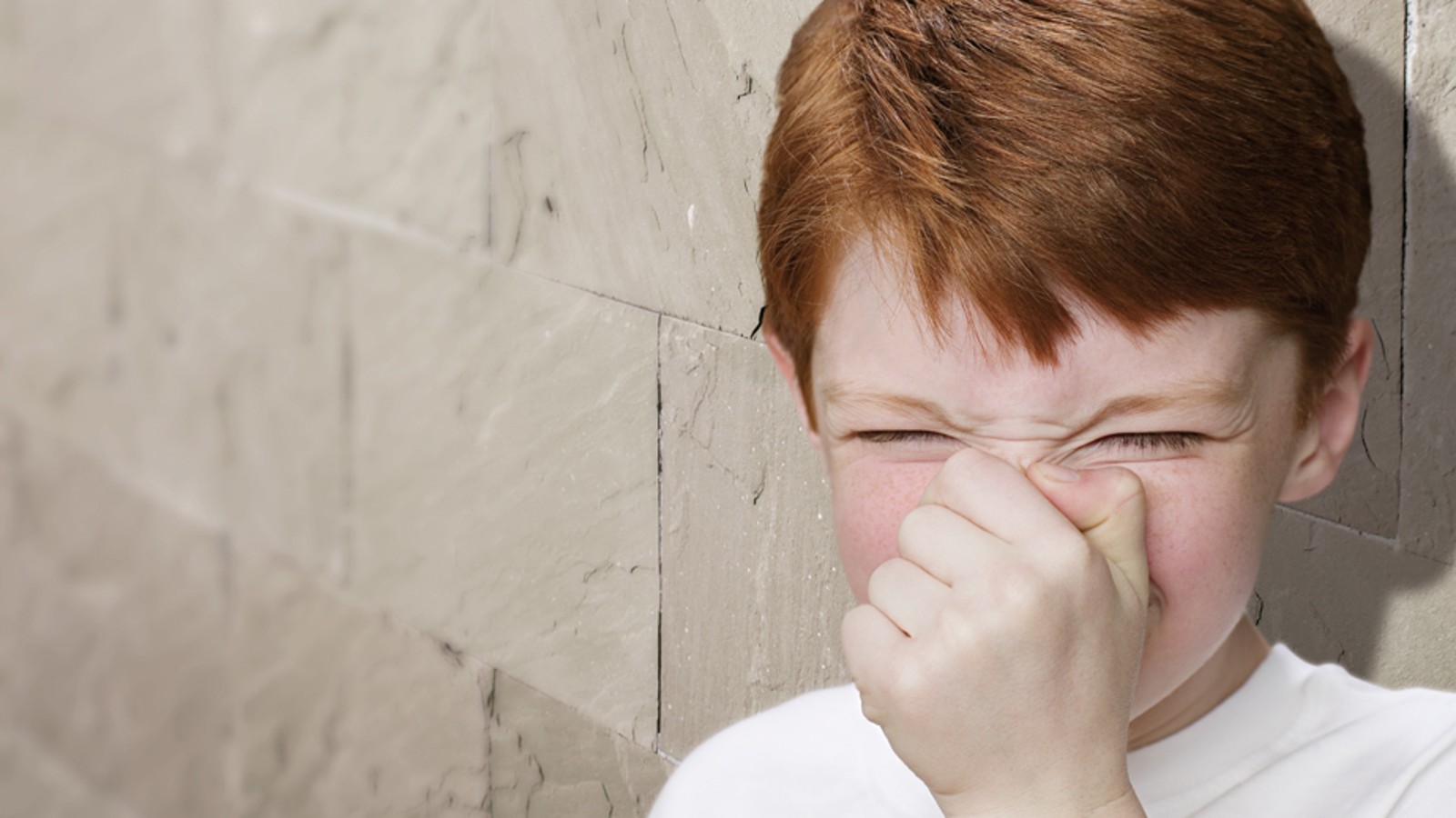 Dreng holder sig for næsen