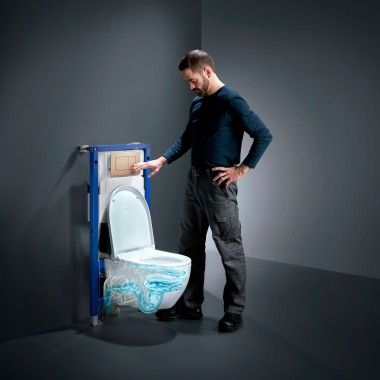 En mand betjener TurboFlush-skylleteknikken på et Geberit Acanto toilet