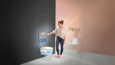 Kvinde, der aktiverer skyllet på Geberit WC-systemet (© Geberit)