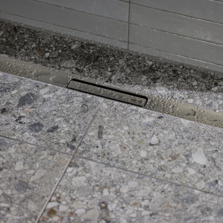 Vandet løber ud via en elegant profil i rustfrit stål. Vandet løber ud via en elegant profil i rustfrit stål.