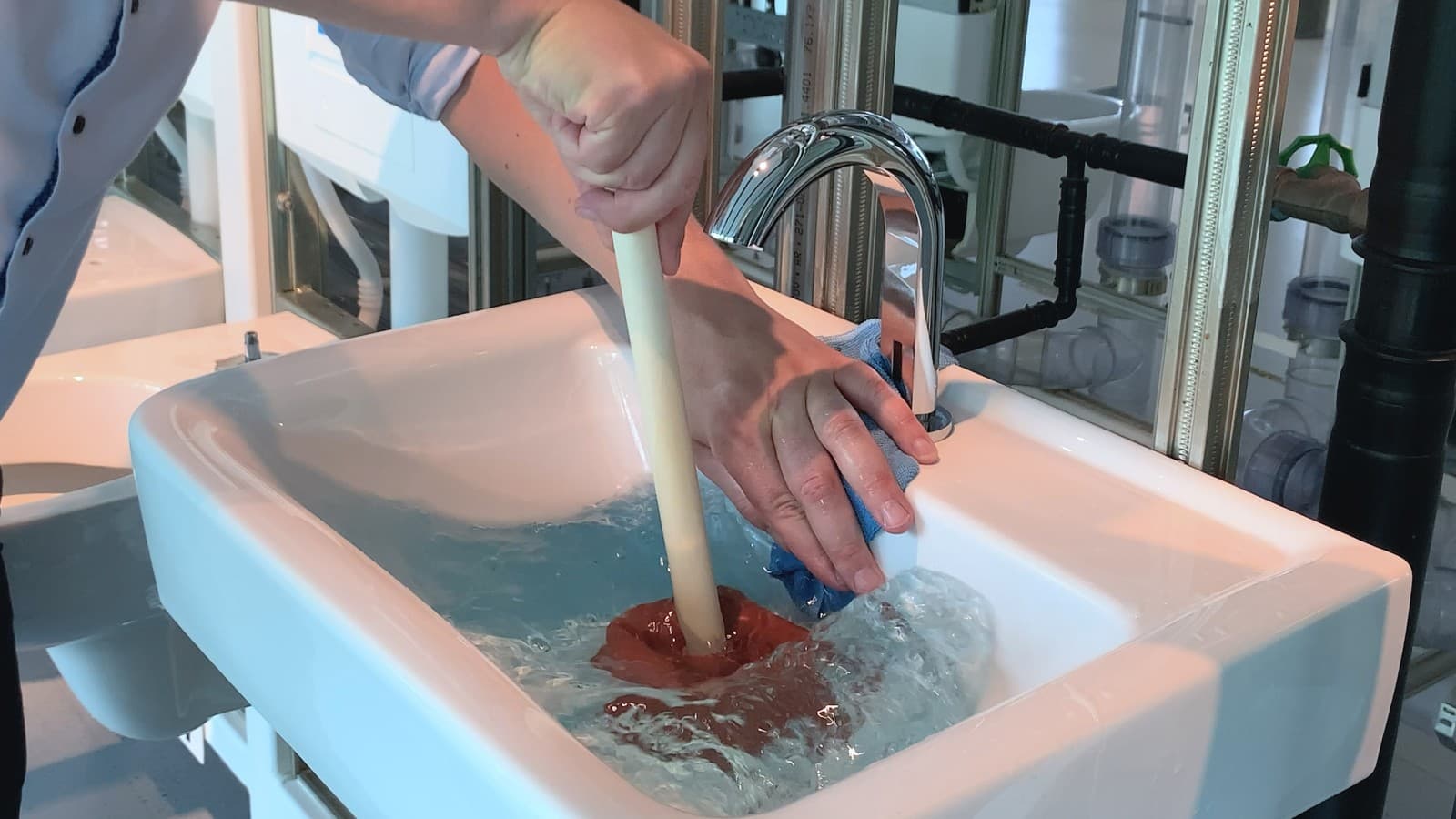 Dæk overløbshullet med din hånd og en klud Dæk overløbshullet med din hånd og en klud