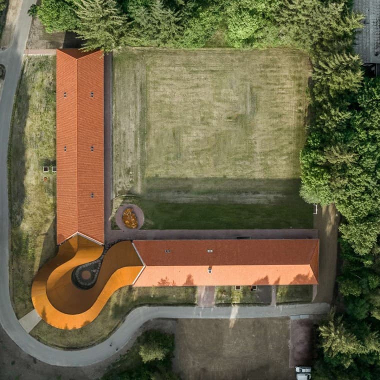 Udsigten fra oven viser den runde nybygning, der forbinder de to historiske bygninger med tegltage (© R_Hjortshoj) Udsigten fra oven viser den runde nybygning, der forbinder de to historiske bygninger med tegltage (© R_Hjortshoj)